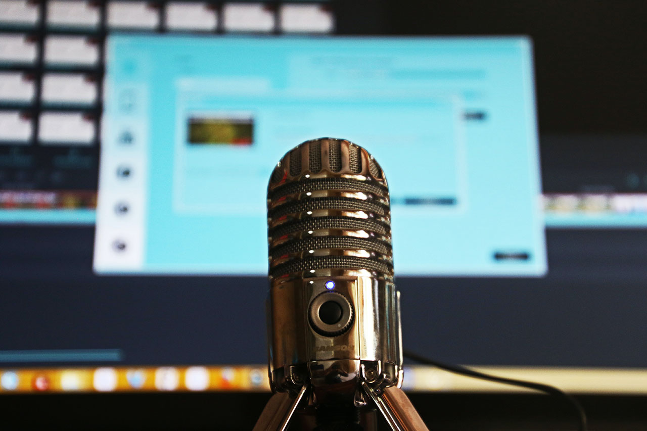 Podcast microphone in front of computer screen