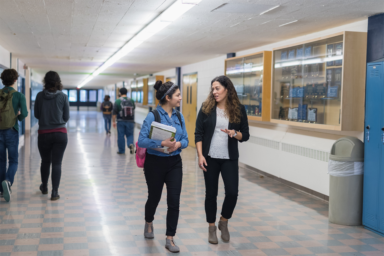 students and teachers walking inside school hallway