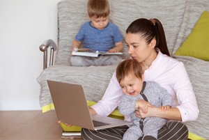 working from home a mom at her laptop with kids