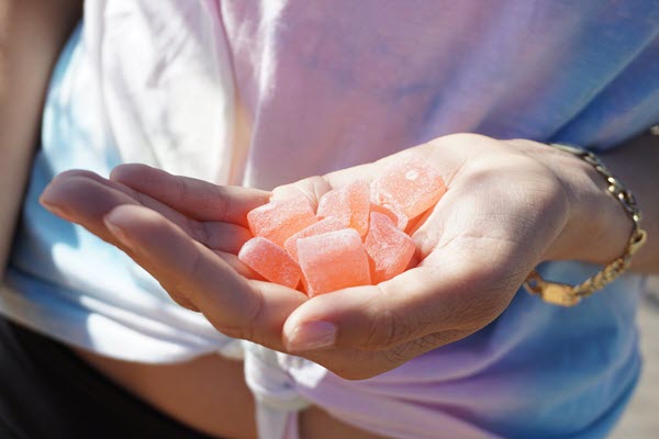 closeup of a person's hand holding a handful of gummies