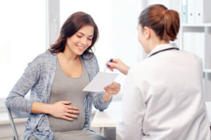 Pregnant women reviewing paper material with healthcare provider