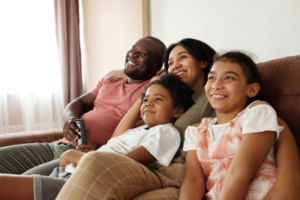 family cuddling on couch looking at wall