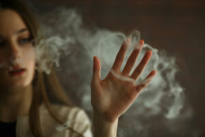 Vaping teenager. Young white girl smokes an electronic cigarette  in vape bar. Bad habit