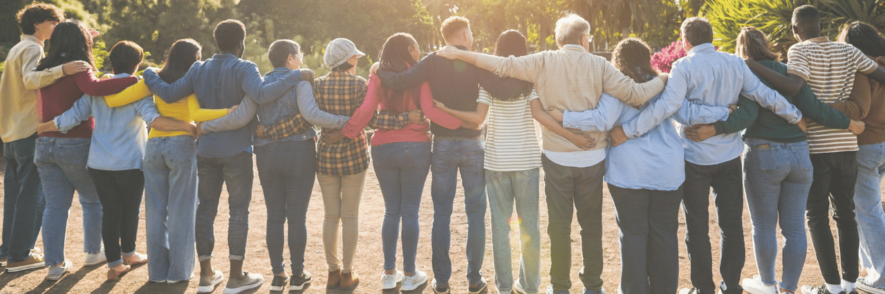 community members of all ages stand shoulder to shoulder in the outdoors
