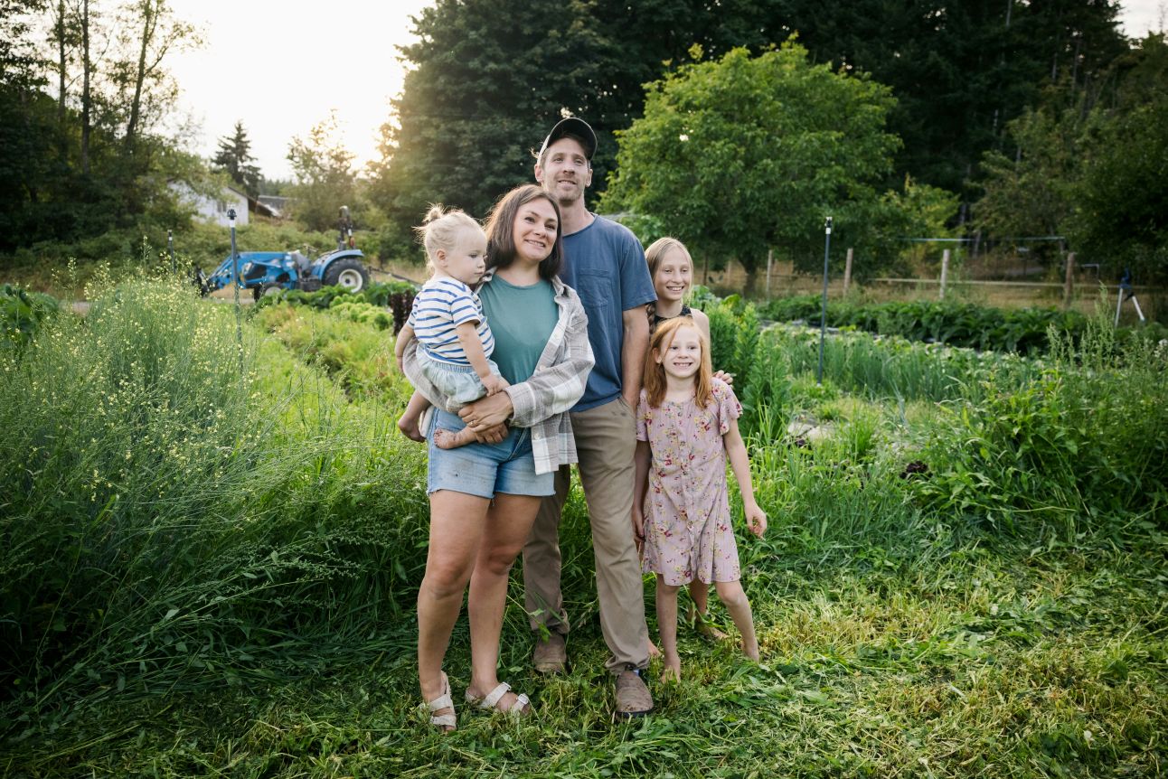 young family standing at the end of their garden rows